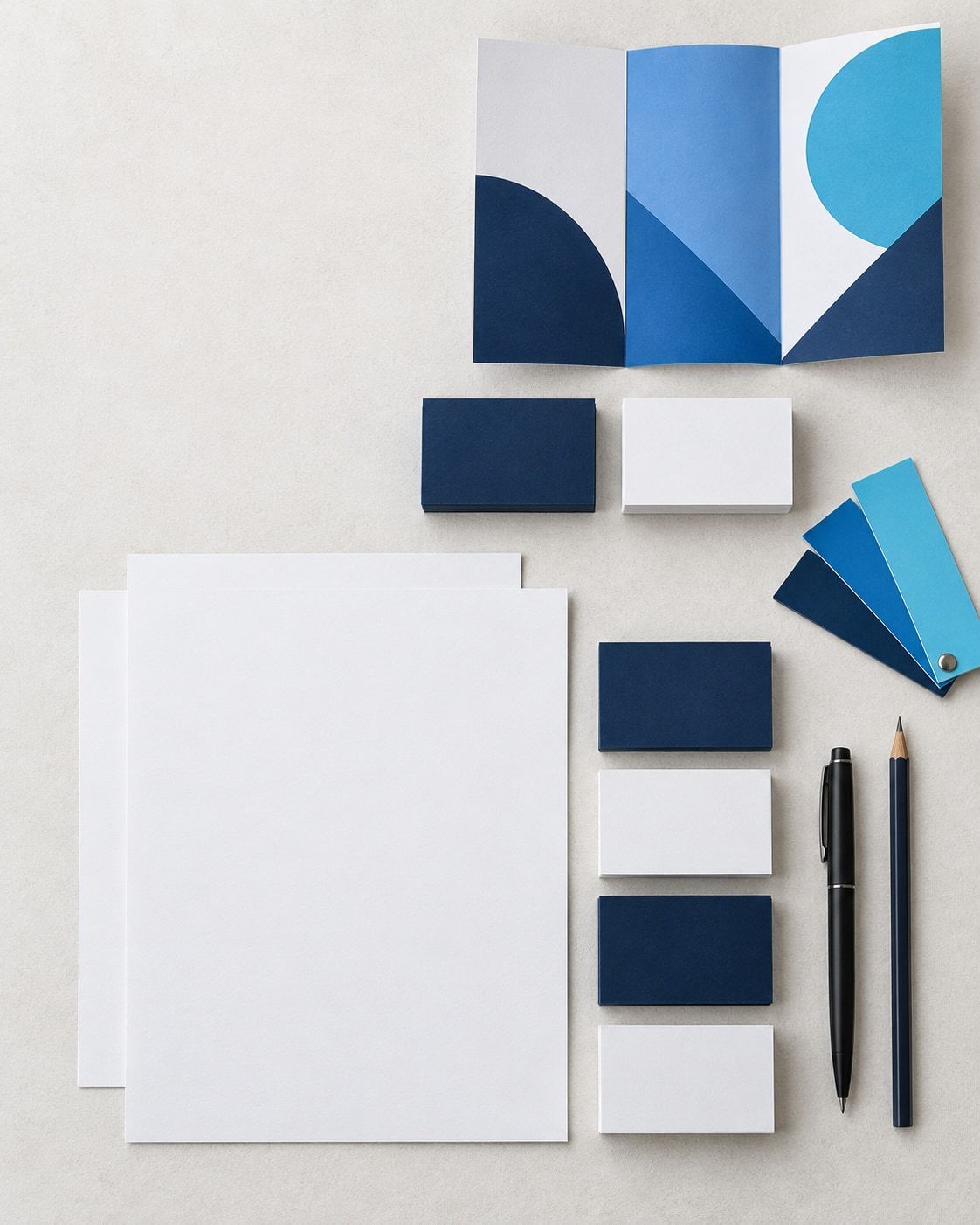 Blank business cards, brochure and colour swatches arranged on a desk