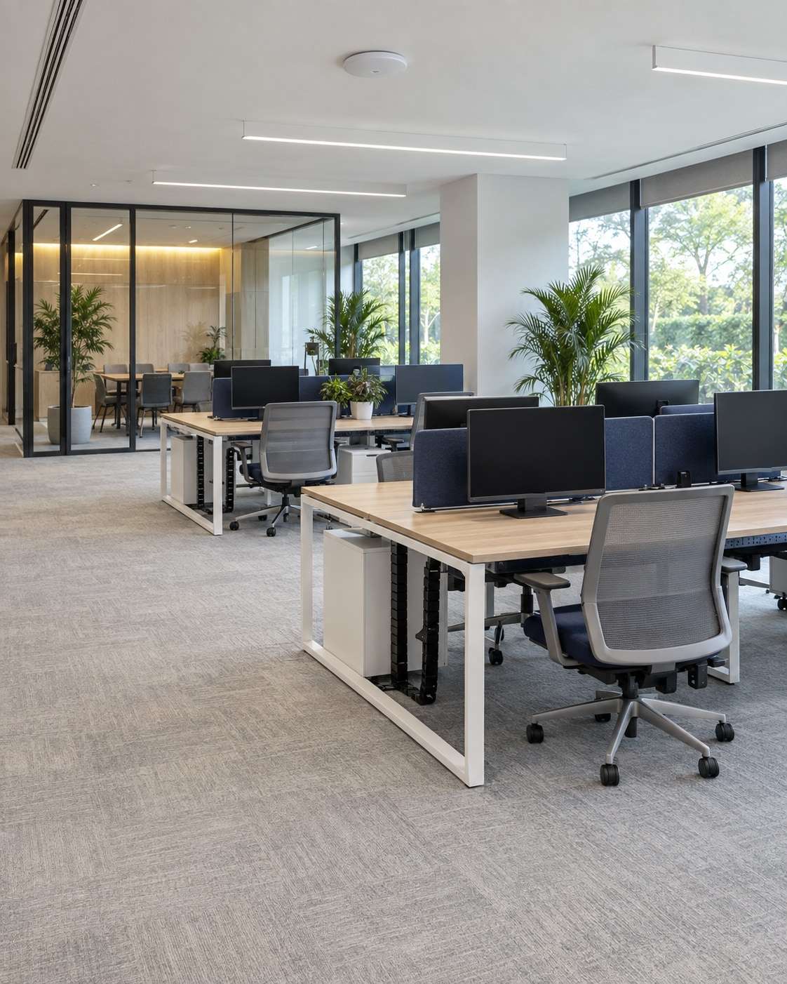 An empty modern open-plan office with desks and a wireless access point on the ceiling